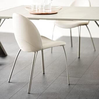 Distinguished Cattelan Italia Holly chair with embossed lacquered steel legs and creamy-white upholstery exhibiting a curved silhouette