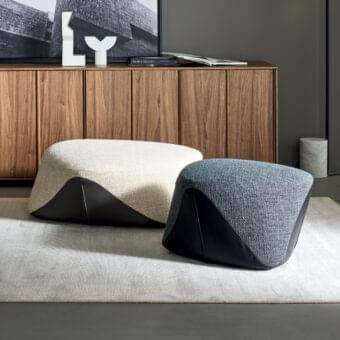 Refined Bonaldo Seki ottoman with light beige textured textile and contrasting dark smooth material lower portion