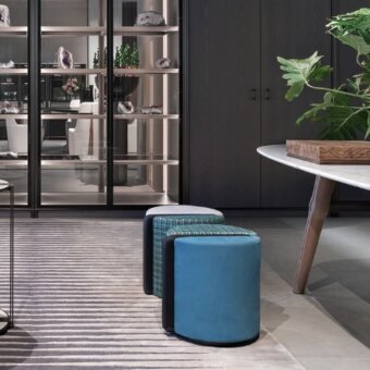 Distinguished Giorgetti Summa ottoman presents a cylinder shape broken down into vertical elements with teal blue finish and central leather
