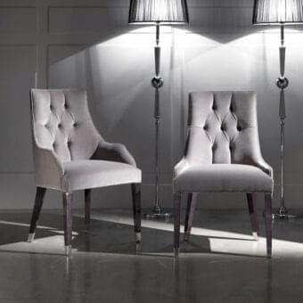 Exceptional DV Home Collection Byron chair with matte grey textile and button-tufted backrest built with dark-toned wood legs capped in silver metal