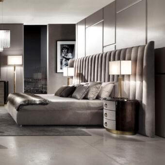 Lavish DV Home Collection Hermes bed with quilted headboard and dark wood bedside tables in gold accents