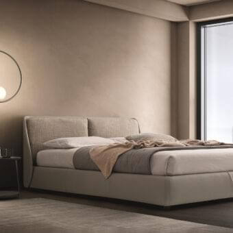Elegant Ditre Italia Bend bed with curvy silhouette, rigid headboard and beige fabric upholstery with leather base cushions