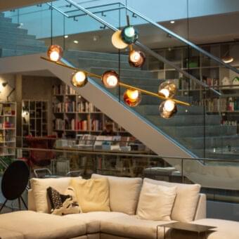 Captivating Bocci 28 Stem suspension lamp with hand-blown glass pendants in amber and teal hues and unlacquered brass stem