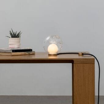 Distinguished Bocci 28 table lamp with transparent hand-blown glass and sleek cylindrical brass base illuminated by an opaque white sphere