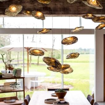Captivating Bocci 73 suspension lamp presents hand-blown glass pendants within a folded ceramic vessel emitting a warm amber glow