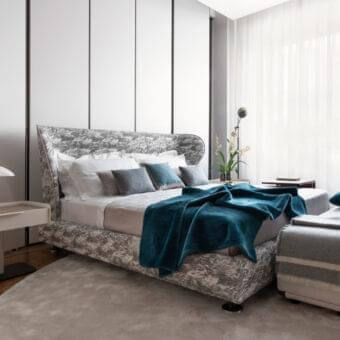 Exceptional Giorgetti Rea bed crafted with mottled gray and white fabric, polished pau ferro, and metal feet