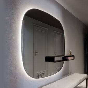 Distinguished Giorgetti Uyuni mirror with rounded reflective surface and suspended solid Canaletto walnut shelf in matte black finish