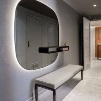 Exclusive Giorgetti Uyuni mirror with a sleek black frame and suspended solid Canaletto walnut shelf with integrated light
