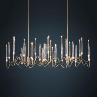 Distinguished Il Pezzo 3 Long Chandelier crafted in hand-forged gold tone brass with clear solid crystal diffusers creating romantic light