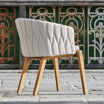 Exceptional Royal Botania Calypso armchair with light gray textured textile and smooth light-toned teak base, built with a geometrically patterned stainless steel backrest