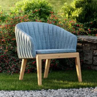 Refined Royal Botania Calypso lounge chair with textured blue textile upholstery and stainless steel teak base