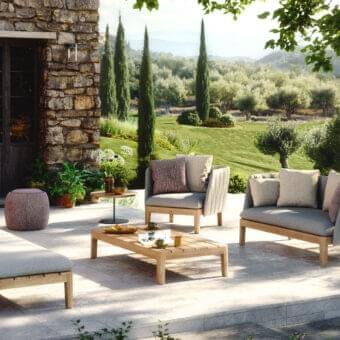 Sophisticated Royal Botania Calypso lounge sofa with teak base and light gray ribbed textile upholstery complemented by brownish-purple cushions