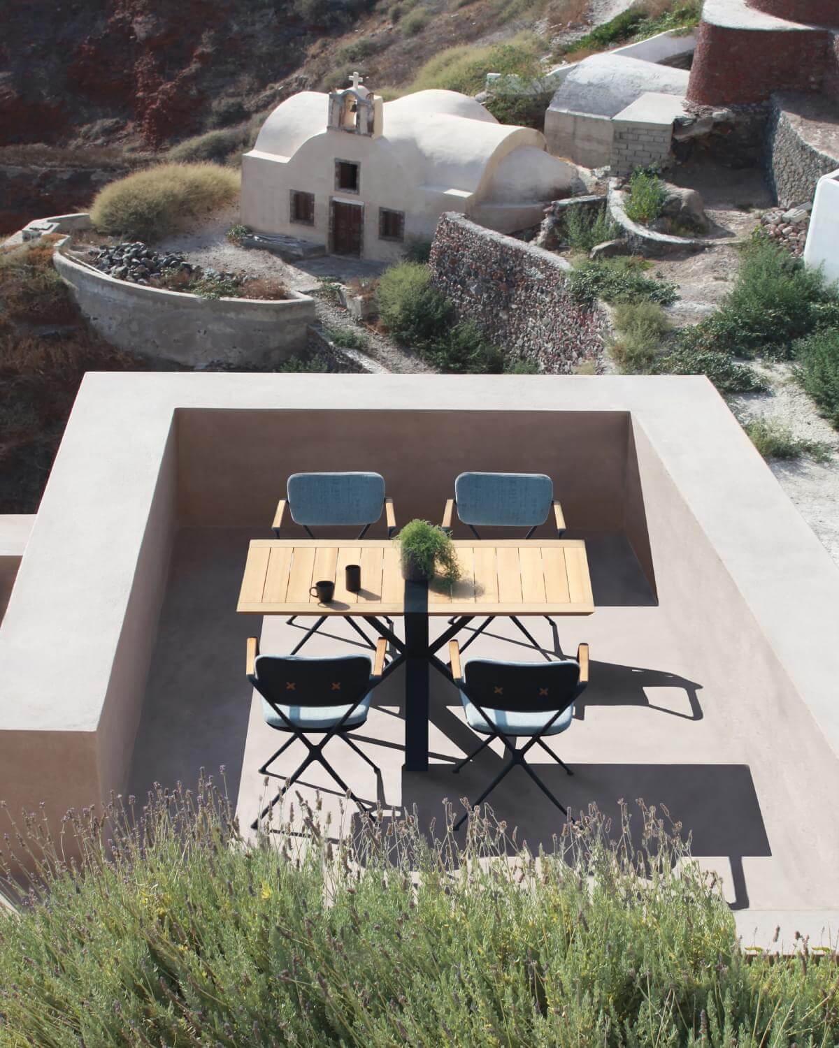 Superior Royal Botania Exes armchair with fluent cast aluminum frame in matte blue and warm tapered teak armrests