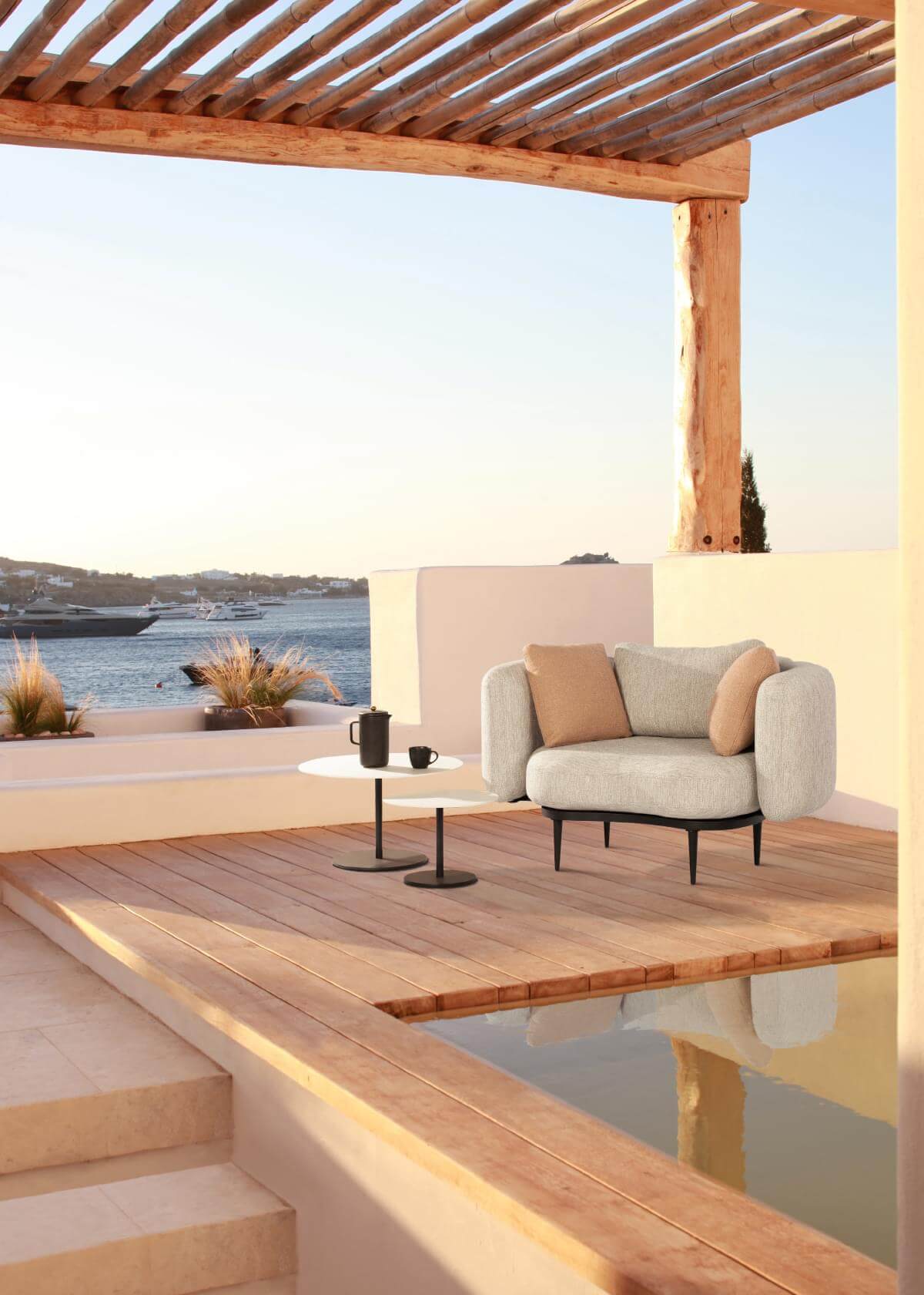 Refined Royal Botania Organix lounge chair with light gray textured seat, tan cushions and dark-toned aluminum base