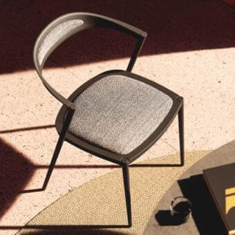 Innovative Royal Botania Styletto chair with dark aluminum frame and light gray woven textile seat offering ergonomic curves
