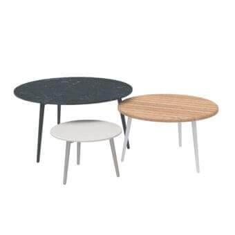 Overlapping circular surfaces with dark stone-like, light wood-like and white finishes on angled, tapered legs against a white backdrop
