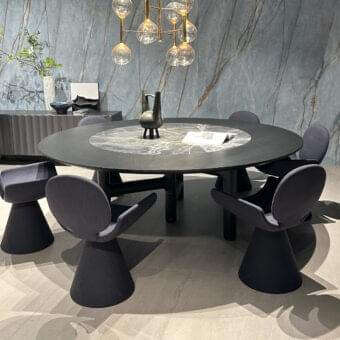 Dark circular arrangement with a patterned central surface, surrounding contoured forms, and suspended illuminated spheres against a veined panel background