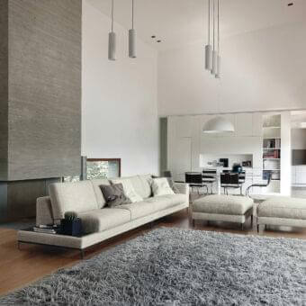 Exclusive Ditre Italia Artis sofa with light beige fabric upholstery and dark finished L-shaped metal legs displaying “Punto Pettine” stitching