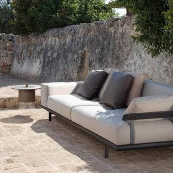 Exclusive Talenti Allure sofa with dark metal frame, light beige cushions and dark-toned wood accents built with brown leather pillows