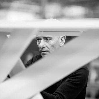 Man’s face partially framed by intersecting light planes with blurred background and soft diffused lighting