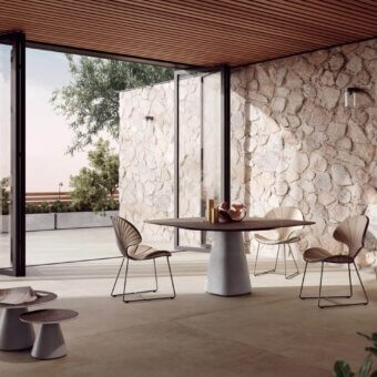 Comfortable Royal Botania Ostrea chair with a black metal frame and beige textile seat, featuring a delicate fan-like backrest and angled legs for outdoor dining