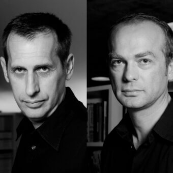Two black and white close-up portraits of men with dark clothing are positioned side by side with soft lighting