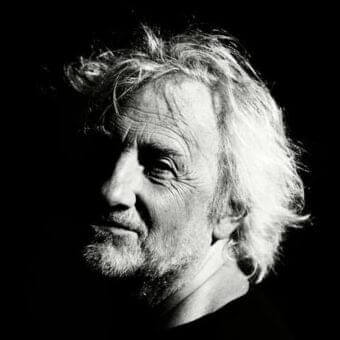 Close-up black and white portrait of a mature man with graying beard looking upwards and to the side