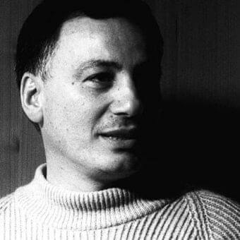 Grayscale portrait of a person facing slightly upward with knitted ribbed garment visible against a dark striated background
