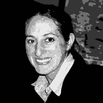 Dark and light grayscale portrait shows a person with short hair and a slight smile looking forward
