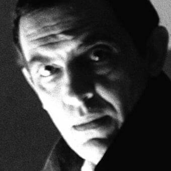 High contrast grayscale portrait of a man facing slightly upward with defined features and shadowed areas