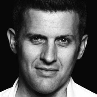 Central black and white portrait shows a man with short dark hair, strong features, and a direct gaze against a dark background