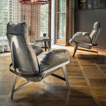 Distinguished Arketipo Jupiter lounge chair with muted gray leather-like shell and folded matte dark gray metal arch structure
