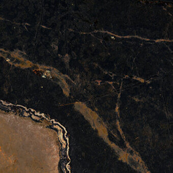 Polished stone texture with black and gold veining, featuring cracks and fissures across a mottled surface, transitioning to beige tones.