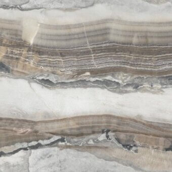 Onice grigio stone slab displays layered bands of white, brown, gray, and black with a smooth, reflective surface and neutral earth tone palette.