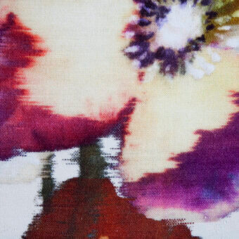 Cream textile sample with watercolor pattern in burgundy, olive, and purple hues, featuring blurred edges and a tight weave.