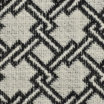 Black and cream checkered textile with intersecting diagonal lines forming asymmetrical squares and rectangles, displaying a textured, handwoven appearance.