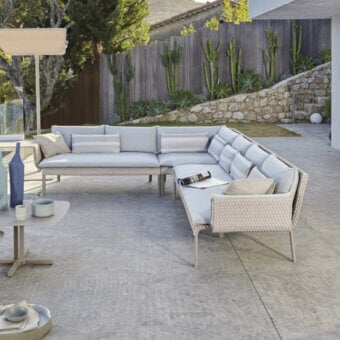 Sophisticated Roberti Rattan Key West sectional with light beige Sunrope and light gray cushions in Cipria powder-coated aluminum construction