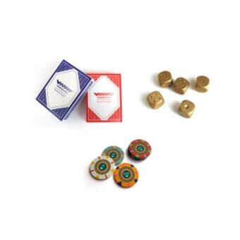 Casino game set with playing cards, brass dice, and colorful casino chips on a white surface, featuring “Royal” card design.