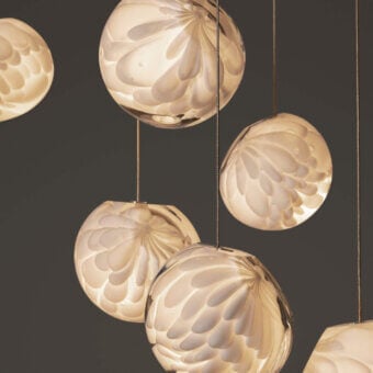 Refined Bocci 118 Linear suspension lamp with nine hand-blown glass pendants exhibiting warm beige and amber tones with a subtly textured surface