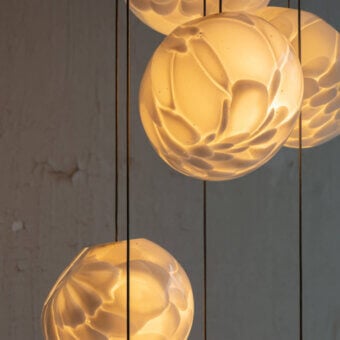 Distinguished Bocci 118 Random Suspension Lamp with translucent glass pendants and satin finish emitting a warm amber glow