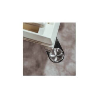 Chrome cup holder attached to white angular furniture, featuring a circular brushed metal disc on a polished chrome bracket.