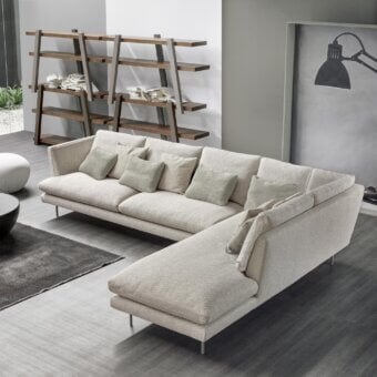 Superior Bonaldo Lars sectional with light beige textile upholstery and slender metal feet, complemented by sage throw pillows
