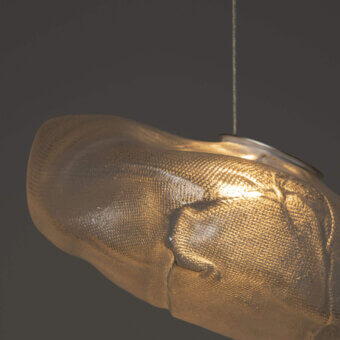 Captivating Bocci 73 suspension lamp with hand-blown glass pendant nestled within folded ceramic, exhibiting a warm golden finish