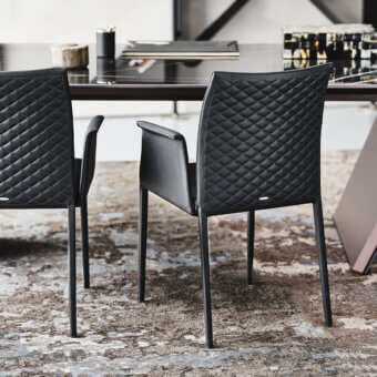 Captivating Cattelan Italia Norma chair in dark synthetic leather with quilted seatback and black steel frame
