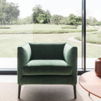 Distinguished Presotto Raffaello lounge chair built in muted green textile with a cockpit structure and cylindrical legs
