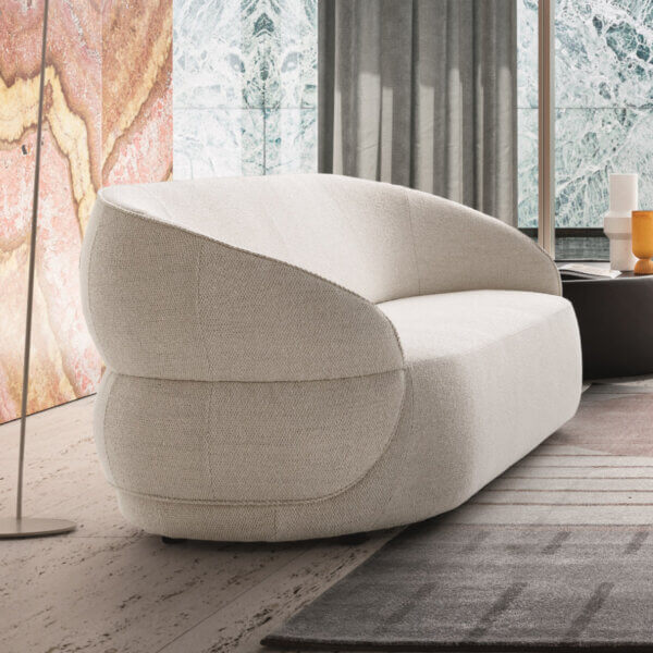 Ditre Italia clip sofa, off-white fabric, rounded cocoon design with high backrest, set in modern interior with marble wall.