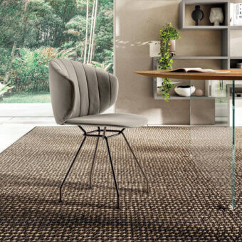 Elegant Lago Ruffle chair with quilted finish and curved silhouette in light gray textile with dark-finished metal legs