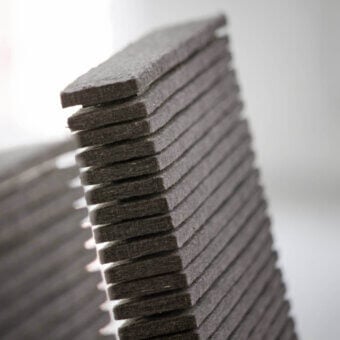 Lago Steps chairs dark gray layered design studio shot, rectangular stacked sections, angular form, neutral background, tapered profile.