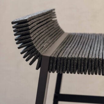 Lago Steps stool, dark gray felt, layered construction with black metal frame and angled backrest, studio lighting.