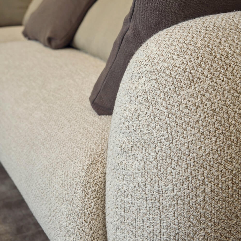 Presotto Bali sofa, cream textured upholstery, rounded armrest with dark brown and beige throw pillows, squared frame.